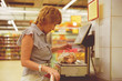 © Mihail - adult woman in the grocery store making food purchases