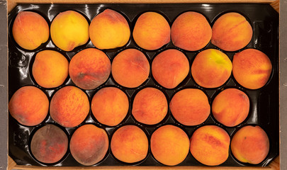 Wall Mural - close up beatiful fresh raw peaches in a wooden crate