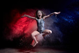 Fototapeta Sport - Small jumping girl during photoshoot with flour in dark studio