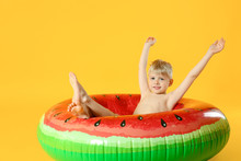 Cute Little Boy With Inflatable Ring On Color Background