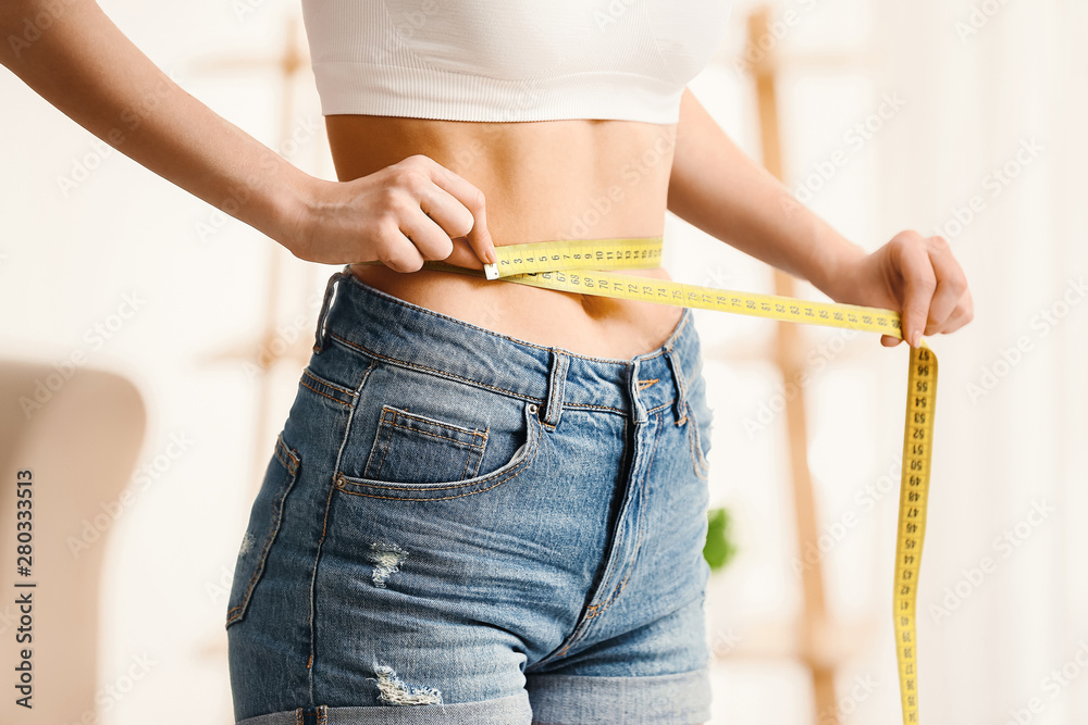 Woman with measuring tape at home. Weight loss concept