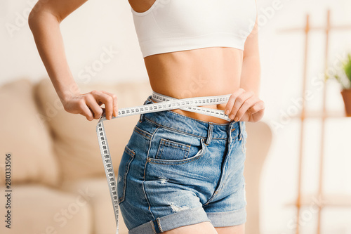 Fotografía Woman with measuring tape at home. Weight loss concept