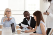 © fizkes - Excited African American employee talk with colleagues at briefing