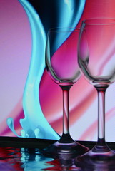 2 wine glasses on a colorful creative background in the form of vertical waves, pink and turquoise