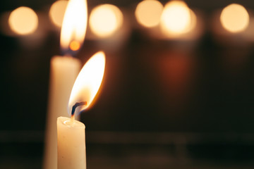 A single burning candle isolated with black background