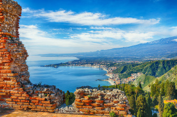 Wall Mural - Aquamarine blue waters of sea near Taormina resorts and Etna volcano mount