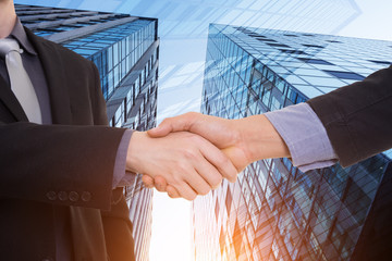 Close up image of hand shake against skyscrapers