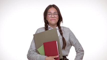 Sticker - Cheerful young brunette girl student with books laughung while looking at the camera over white background isolated