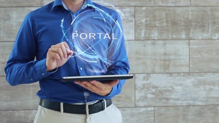 Man activates a conceptual hologram with text Portal. The guy in the blue shirt and light trousers with a holographic screen gadget on the background of the wall
