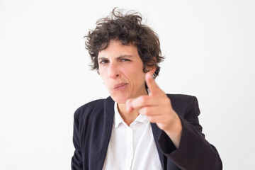 Wall Mural - Serious businesswoman pointing at camera. Professional middle aged business leader pointing with finger and looking at camera isolated on grey background. Gesture concept