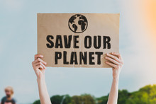 Person Holding Brown Save Our Planet Cardboard Poster. Save The Planet On A Paper Banner In Men's Hand. Human Holds A Cardboard With An Inscription: Save Our Planet