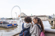 Two young teenagers stand indicate the London Eye