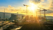 Time-lapse Footage Of A Large Construction Site With Several Busy Cranes In Golden Sunlight