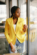 © prostooleh - Elegant black woman. Lady in a yellow jacket. Businesswoman working in a office
