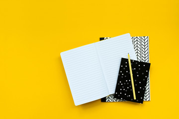 Wall Mural - Back to school concept. School supplies: open notebook and pen on yellow background. Top view. Copy space. Flat lay. Mock-up