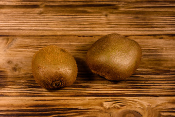 Two kiwi fruits on a wooden table