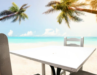 Table background with beautiful blue ocean and sandy beach view. Summer sunny day in distance. 