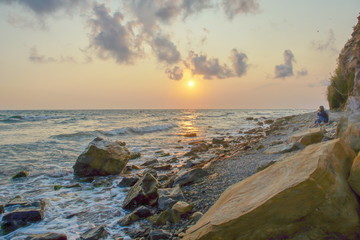 Wall Mural - seascape sunset the sun sets the sea wave the sea foam. stones coast