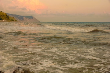 Wall Mural - seascape sunset sun sets orange Cumulus clouds sea waves. stones coast