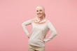 Smiling young arabian muslim woman in hijab light clothes posing isolated on pink background studio portrait. People religious Islam lifestyle concept. Mock up copy space. Standing with arms akimbo.