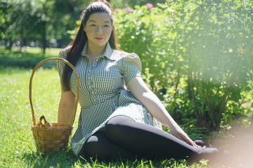 Wall Mural - Asian girl resting in the summer in the Park in the intense heat in the bright sun alone