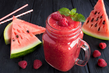 Wall Mural - Smoothies from watermelon and raspberries  on the black  wooden background