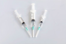 Several Different Syringes On A White Smooth Table Are Filled With Mortar And Ready For Use And Point To The Lower Center.