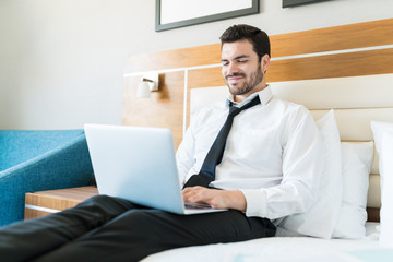 Wall Mural - Male Entrepreneur Using Laptop In Hotel Room