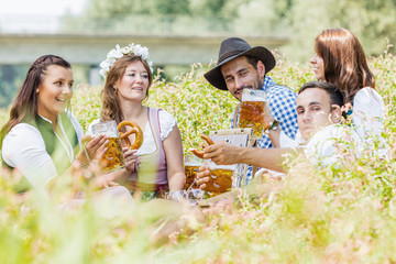 Wall Mural - Five friends having fun on Bavarian RIver and clinking glasses with beer