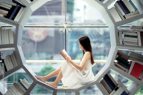 Fotografía Asian girl student read a text book in library in her University