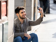 © SB Arts Media - Young attractive man taking selfie while on holidays in European city outdoors