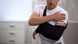 Male in arm sling suffering pain in shoulder, result of work trauma, orthopedics