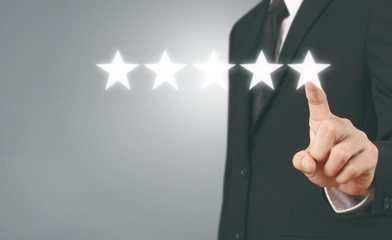 Hand touching five star symbol to increase rating