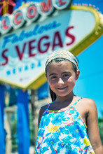 Young Girl Standing Happy Under The Famous Las Vegas Sign On Bright Sunny Day, Nevada. Tourism Concept