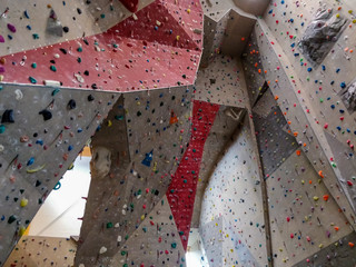 Artificial indoor climbing wall full of hand grips.