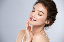 Young And Happy Girl With Light Make-up And Closed Eyes Touching Her Chin And Smiling