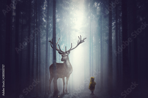 Fotografía Kleines KInd steht vor einem großen Hirsch im Wald