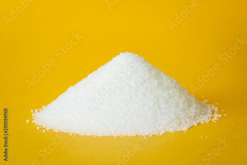Fotomural Heap of sugar on yellow background