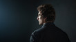 © Ulia Koltyrina - A young man with broad shoulders and a clear profile, in a dark shirt. Portrait from the back in half a turn.