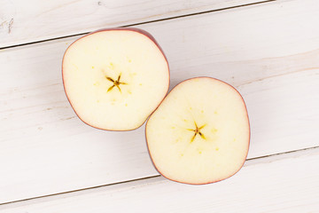 Group of two halves of fresh apple red delicious flatlay on white wood