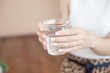 © Viktoria - Female hands holding a clear glass of water.A glass of clean mineral water in hands, healthy drink