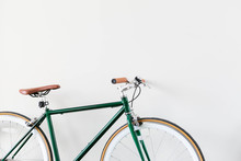 Fixed Green And Brown Bicycle In Modern Home, Fixie Bike Inside Hous​e, White Wall Background, Isolated Retro Bicycle 