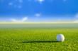 Golf ball on green grass with blur background