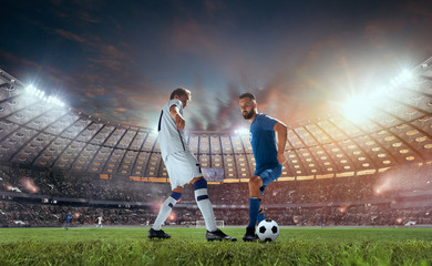 Canvas Print - Soccer players in action on professional stadium on sunset.