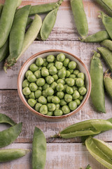 fresh raw peas on a wooden table