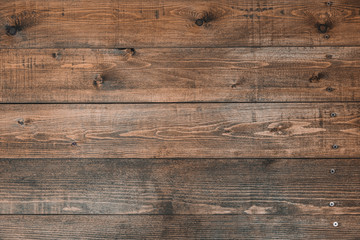 Old brown wood background made of dark natural wood in grunge style. The view from the top. Natural raw planed texture of coniferous pine. The surface of the table to shoot flat lay. Copy space