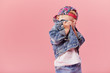 © oes - Little serious fashionable toddler boy in denim clothes and trendy cap. Isolated on pink background