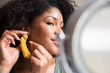 © jamie grill photography/Stocksy - Woman putting on earring