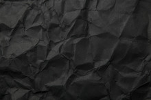 Texture Of Black Crumpled Paper. Dark Paper Background With Chaotic Bends. A Sheet Of Black Wrinkled Paper