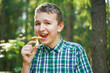 © goldeneden - teenager boy with mushroom in the forest in summer day wanna to eat it